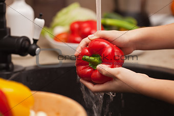 Making a vegetables salad, washing ingredients - red bell pepper