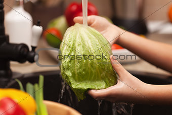 Making a vegetables salad, washing ingredients 