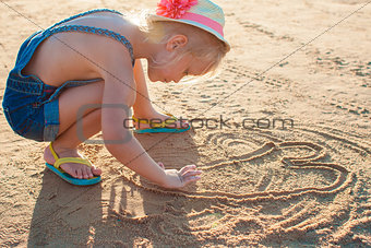 Cute little girl playing with sand on the beach