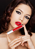 Beautiful model girl holding liquid red lipstick