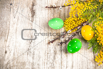 Easter eggs top view spring yellow flowers branch