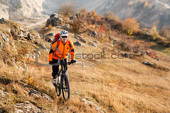 Bike cyclist with red backpack riding single track