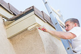Professional Painter Using Small Roller to Paint House Fascia