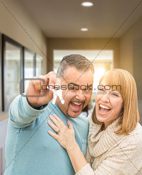 Couple Holding House Keys Inside Hallway of Their New Home