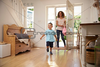 Excited Boy Returning Home From School With Mother