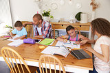 Parents Helping Children With Homework At Table
