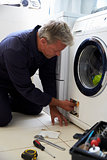 Plumber Fixing Domestic Washing Machine