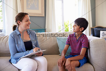 Young Boy Talking With Counselor At Home
