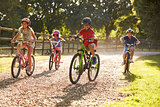 Four Children On Cycle Ride In Countryside Together