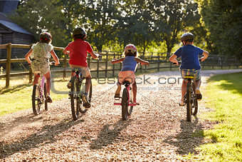 Rear View Of Children On Cycle Ride In Countryside Together
