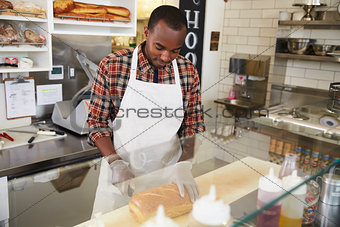 Man working behind the counter at a sandwich bar