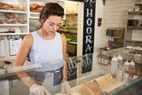 Woman preparing food behind the counter at a sandwich bar