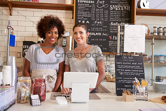 Two women behind the counter at a coffee shop, close up