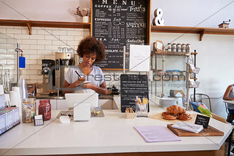Waitress writing down an order at the counter of coffee shop