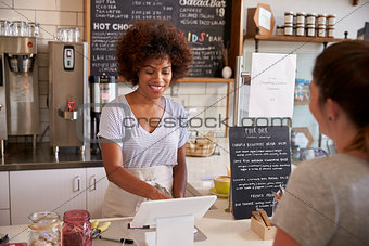 Waitress taking a customerÕs order at till in a coffee shop