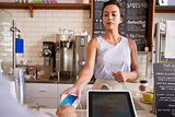 Waitress at coffee shop taking card payment from a customer
