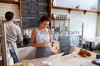 Couple working behind the counter at a coffee shop, close up