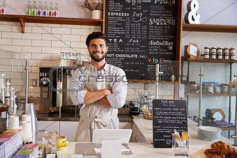 Business owner at the counter of coffee shop, arms crossed