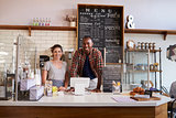 Mixed race couple waiting behind counter at a coffee shop