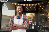 Black male business owner standing outside coffee shop