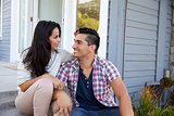 Affectionate Couple Sitting On Steps Outside Home