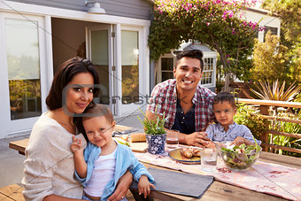 Portrait Of Family At Home Eating Outdoor Meal In Garden