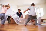 Family Unpacking Boxes In New Home On Moving Day