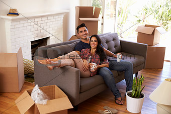 Couple On Sofa Taking A Break From Unpacking On Moving Day