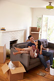 Couple On Sofa Taking A Break From Unpacking On Moving Day