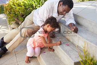 Grandfather And Granddaughter Drawing Picture On Steps