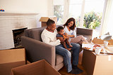 Family Take A Break On Sofa With Pizza On Moving Day