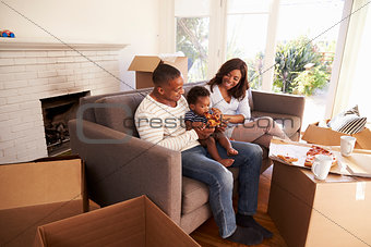 Family Take A Break On Sofa With Pizza On Moving Day