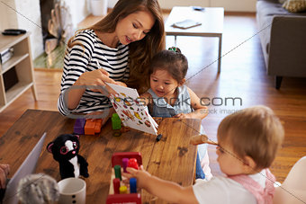 Mother Playing With Children On Table At Home