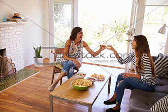 Two Female Friends Socializing Together At Home