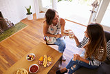 Two Female Friends Socializing Together At Home
