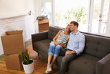Couple Taking A Break On Sofa During Moving In Day