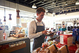 Employee In Delicatessen Checking Stock With Digital Tablet