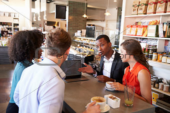 Business Group Having Informal Meeting In Cafe