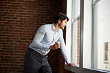 Businessman Standing By Office Window With Coffee