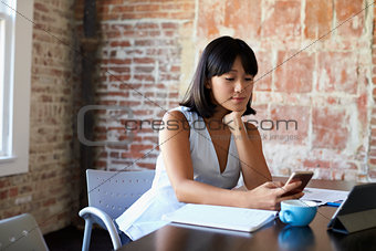 Businesswoman Working In Boardroom And Checking Mobile Phone