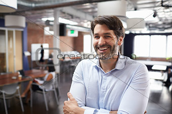 Businessman Standing In Modern Open Plan Office