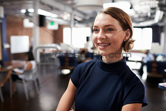 Businesswoman Standing In Modern Open Plan Office