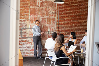 Businesspeople Meeting In Modern Boardroom Through Doorway
