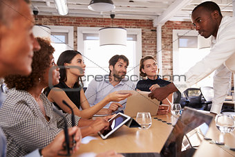 Businesspeople Meeting Around Table In Modern Office