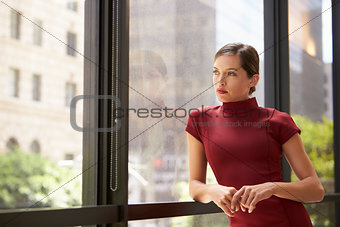 Young white businesswoman looking out of office window
