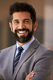 Middle aged Hispanic businessman smiling to camera, close up