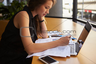 Businesswoman working in office, side view, close up
