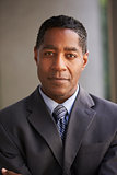 Middle aged black businessman looking at camera, vertical