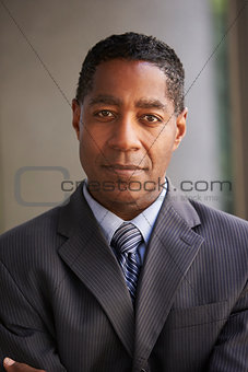 Middle aged black businessman looking at camera, vertical