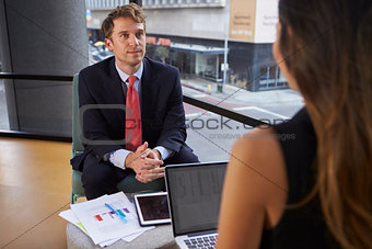 Young businessman and woman at an informal meeting in office